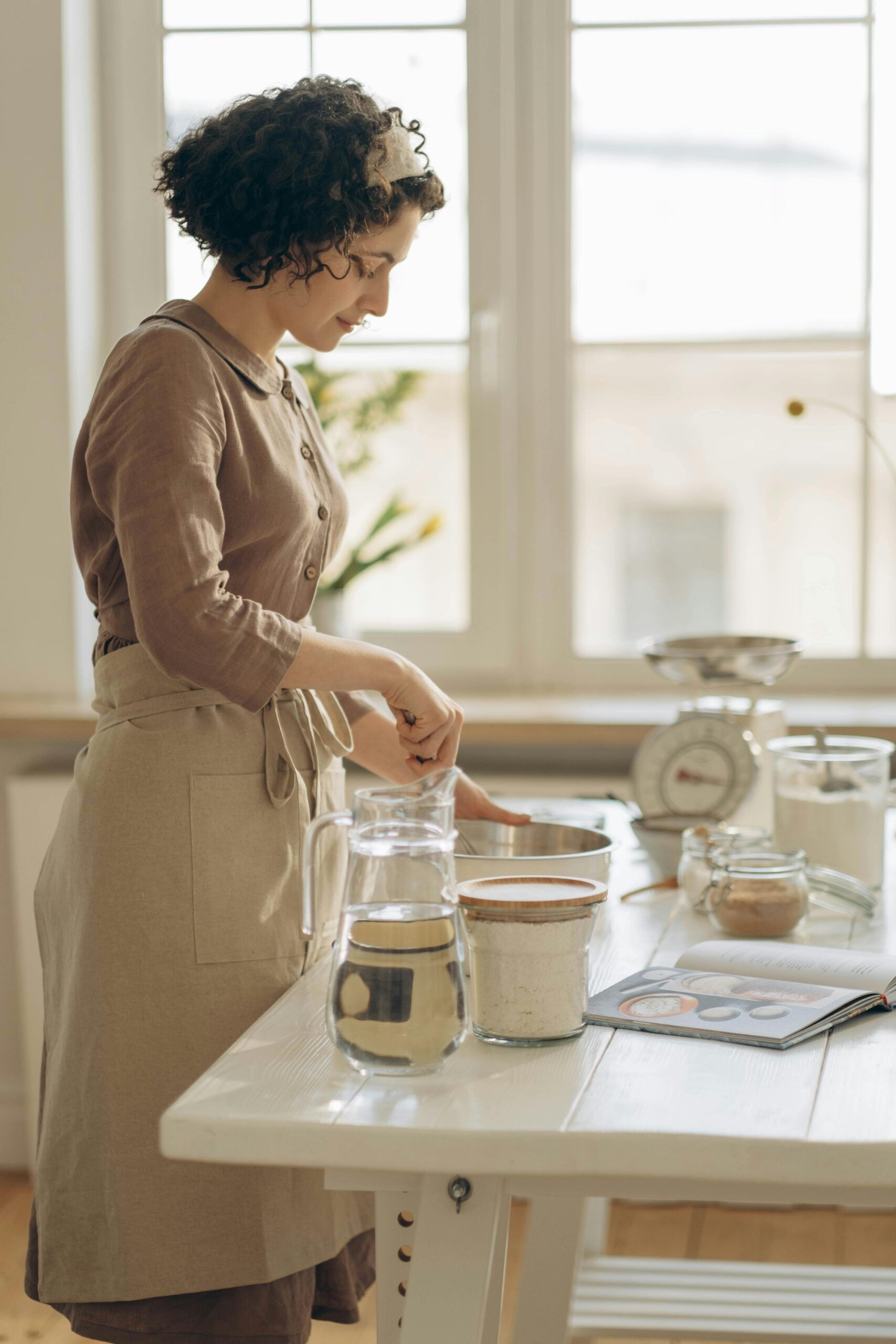 Woman preparing a baking recipe in a bright, home kitchen.